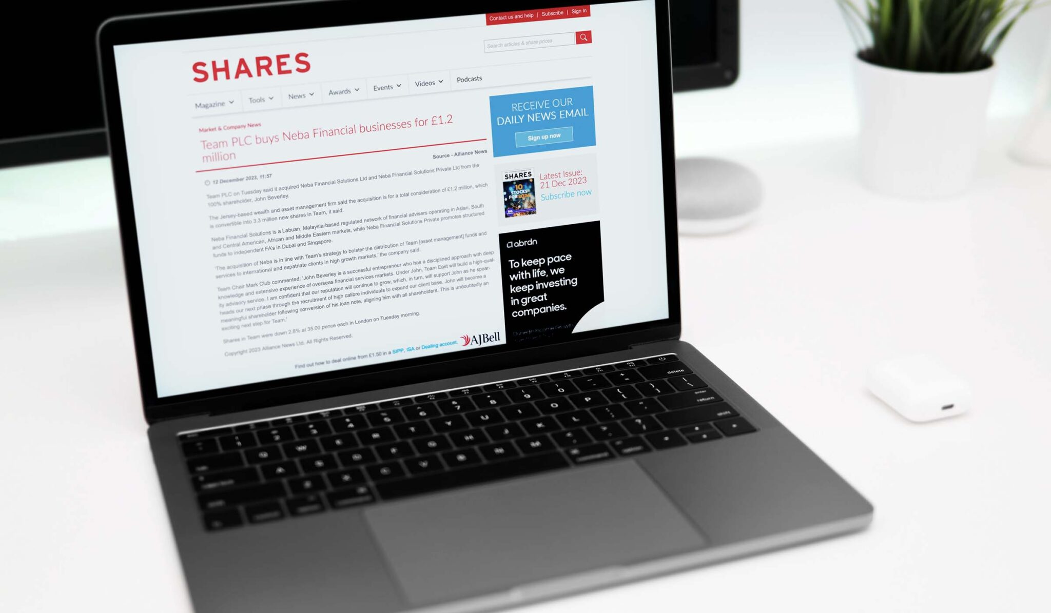Laptop showing Shares magazine coverage of TEAM buying the NEBA financial businesses for £1.2 million