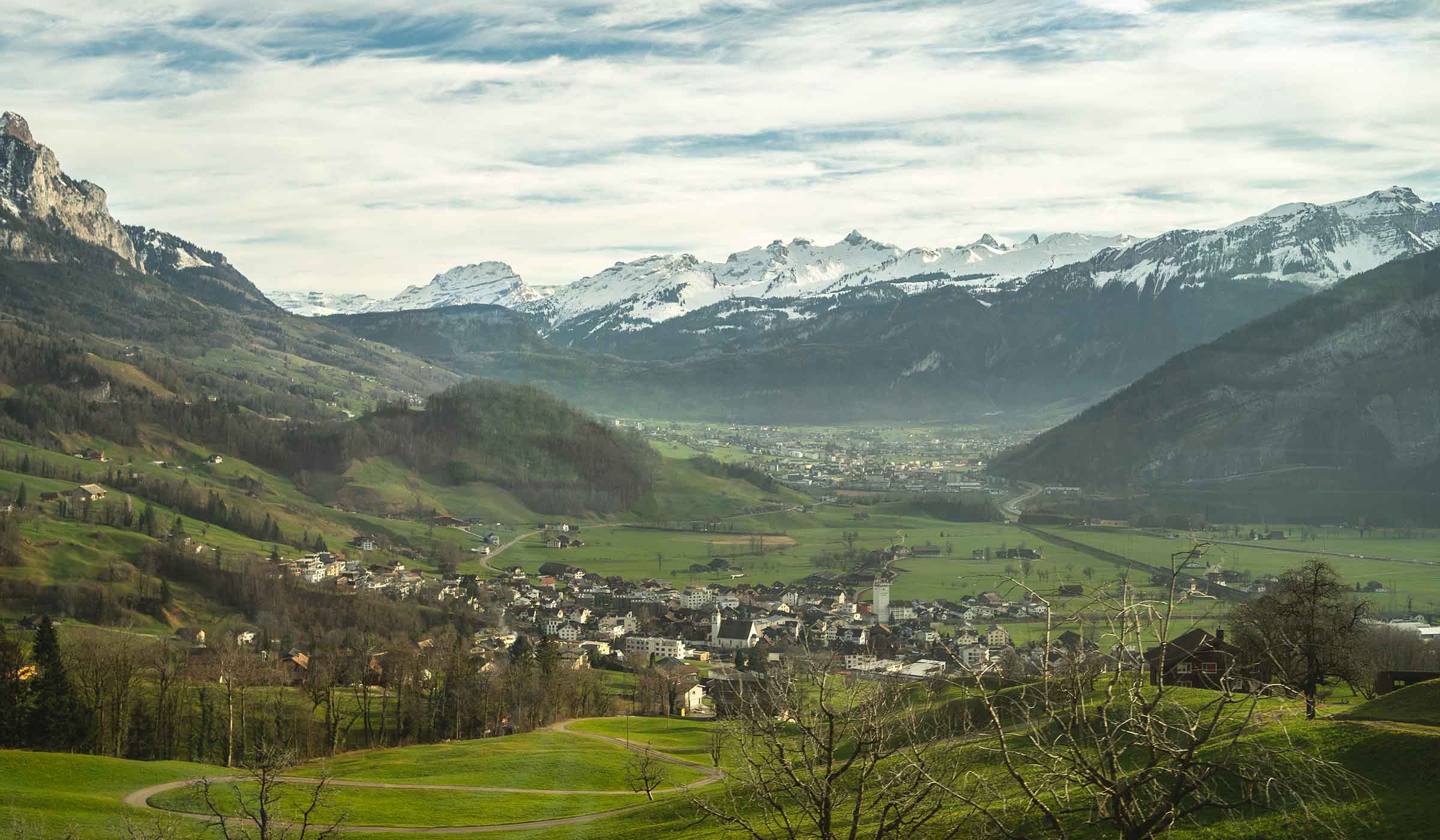 Alpine valley beneath snow-capped mountains